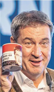  ?? FOTO: ARMIN WEIGEL/DPA ?? „Schön, dass es mich gibt! Markus“steht auf der Tasse von Markus Söder. Diese hat der bayerische Ministerpr­äsident zuvor auf dem Gillamoos als Geschenk bekommen.