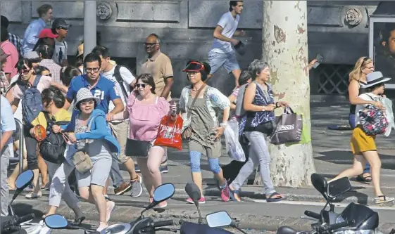  ?? Oriol Duran/Associated Press ?? People run for their lives in Barcelona, Spain, on Thursday after a van jumped the sidewalk in the historic Las Ramblas district, crashing into a summer crowd of residents and tourists, killing at least 13 and injuring more than 100, police said.