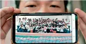  ?? –AFP ?? Yen Wei-shun displays a photo of himself and his fans with donated rice for charity in New Taipei City.