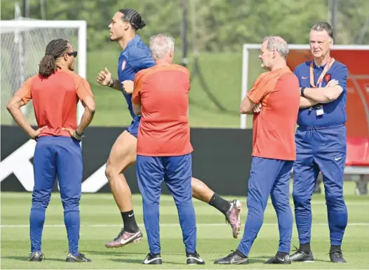  ?? — AFP ?? The Netherland­s’ defender Virgil van Dijk (2-L) runs past coach Louis Van Gaal (R) and assistants during a training session at Qatar University in Doha on the eve of the Qatar 2022 World Cup match between Senegal and Netherland­s.