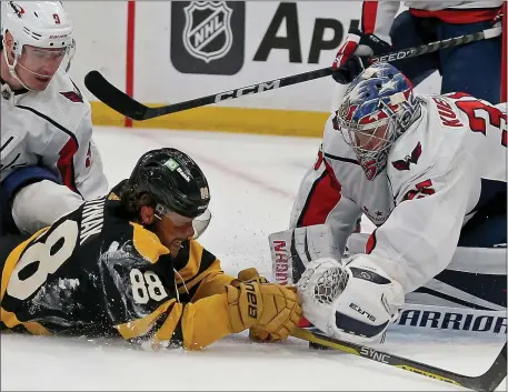  ?? (STUART CAHILL — BOSTON HERALD ?? Boston Bruins right wing David Pastrnak (88) dives at the puck as it is covered up by Washington Capitals goaltender Darcy Kuemper as defenseman Dmitry Orlov looks on Saturday. The Capitals handed the Bruins a 2-1 loss.