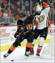  ?? TOM MIHALEK — THE ASSOCIATED PRESS ?? Philadelph­ia Flyers’ Sean Couturier, left, had a goal and two assists in Saturday’s 5-2 win over the Ducks.