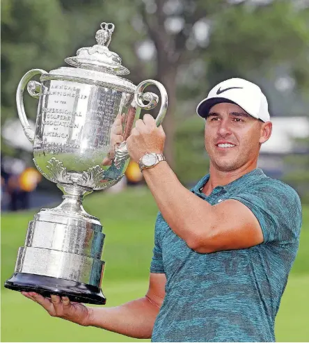  ?? [AP PHOTO] ?? Brooks Koepka holds the Wanamaker Trophy after winning the PGA Championsh­ip on Sunday at Bellerive Country Club in St. Louis. Koepka held off Adam Scott and Tiger Woods to win.