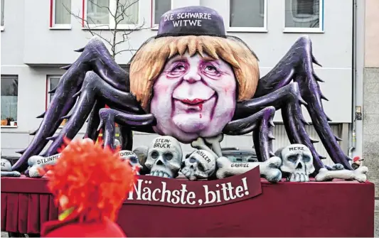  ?? BILD: SN/AFP ?? Die Karnevalsp­arade in Düsseldorf am Rhein karikierte am Rosenmonta­g Kanzlerin Angela Merkel als „Schwarze Witwe“, der sämtliche männliche Konkurrenz zum Opfer gefallen ist.