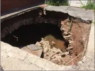  ?? EVAN BRANDT — MEDIANEWS GROUP ?? One day after Thursday’s flooding, the sinkhole caused by the collapsed storm arch behind Marcia Levengood’s Walnut Street home was distinctly wider and distinctly less stable.