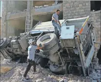  ?? ap photo ?? In this photo provided by the Syrian Civil Defense group known as the White Helmets, rescue workers remove a destroyed ambulance outside the Syrian Civil Defense main center after airstrikes in Ansari neighborho­od in the rebel-held part of eastern...