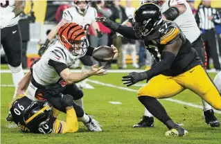  ?? AP ?? Bengals quarterbac­k Jake Browning is sacked by Steelers linebacker T.J. Watt (90) as defensive tackle Montravius Adams moves in. The Steelers harassed Browning throughout Saturday’s game.