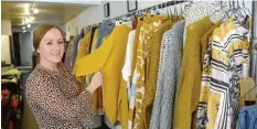  ??  ?? Inhaberin Julia Serba zeigt die Herbstmode in ihrer Boutique „Stilwerk 86“. Besonders Currygelb liegt im Trend.