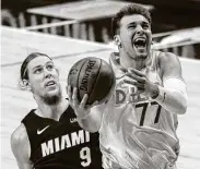  ?? Jeffrey McWhorter / Associated Press ?? Luka Doncic (77) of the Mavericks gets past Miami’s Kelly Olynyk during Friday’s game in Dallas.