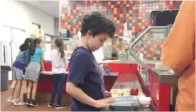  ??  ?? SANTA FE, New Mexico: Photo shows third grade student Lucas Jameson taps in his student identifica­tion number to deduct a meal payment at Gonzales Community School in Santa Fe.