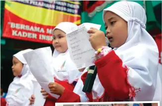  ?? CHANDRA SATWIKA/JAWA POS ?? BERBAKAT: Aulia Nisa (kanan), siswa kelas I SD Muhammadiy­ah 15, ketika membacakan pidato berbahasa Arab pada lomba pidato empat bahasa kemarin.