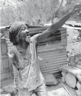  ?? SIMONE MORGAN-LINDO ?? Everald Gayle talks about how a rock, followed by mud and flood water rolled into his house in Shooters Hill, St Andrew in October 2020. He now lives in the hut seen in the background.