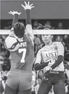  ?? ?? University of Santo Tomas Golden Tigresses’ Jonna Perdido hammered the ball over the defense of De La Salle University Lady Spikers’ Shevana Laput.