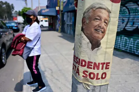  ?? Pedro Pardo, Afp/getty Images ?? On Friday in Ixtapaluca, a woman stands near a poster promoting Sunday’s recall election of Mexican President Andres Manuel Lopez Obrador.