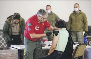  ?? Irfan Khan Los Angeles Times ?? L.A. COUNTY has ended its COVID-19 vaccinatio­n mandate for most of its workforce, clearing the way for firefighte­rs, deputies and others to be hired without the shot. Above, a 2021 vaccinatio­n site in Pomona.