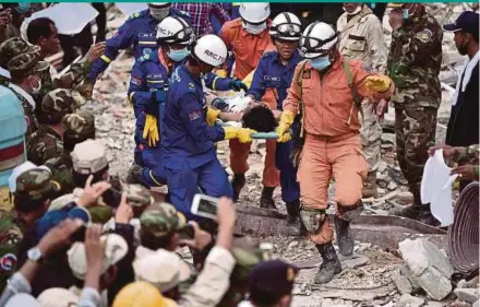  ?? REUTERS PIC ?? A rescue team carrying a wounded worker from a collapsed building in Sihanoukvi­lle, Cambodia, on Monday.