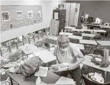  ?? Jon Shapley / Houston Chronicle ?? Dee Julian, a Kingwood High AP English teacher, gathers supplies from her flood-damaged classroom Friday.