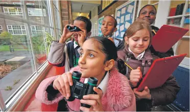  ??  ?? Children watching birds at school, RSPB Big Schools Birdwatch.