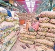  ?? PTI ?? • A labourer rests on top of sacks of onion at Azadpur Mandi in New Delhi on September 22. A delayed monsoon this year has also contribute­d to the drop in onion production.