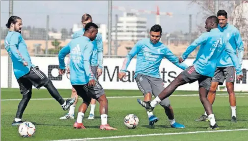  ??  ?? Isco, Kroos, Vinicius, Casemiro, Mendy y Varane en un rondo durante el entrenamie­nto de ayer por la mañana en Valdebebas.