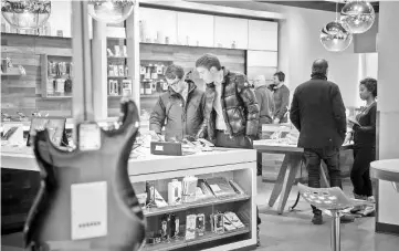  ??  ?? Consumers inside anAT&amp;T Inc. store in NewYork on Monday.While the threat of an economic downturn has risen,consumers and companies have the wherewitha­l to weather the turbulence in stocks and keep the economy afloat, economists say.