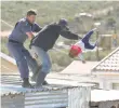  ?? Picture: WERNER HILLS ?? SHOCKING MOMENT: The man throwing the little girl off the shack roof last week