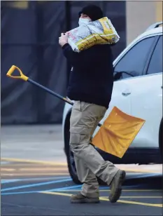  ?? Erik Trautmann / Hearst Connecticu­t Media ?? A customer buys a shovel and rock salt to melt snow at Lowe’s on Wednesday in Norwalk.