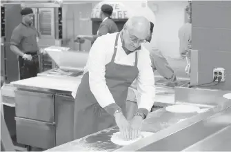  ??  ?? Bruno Abate, chef-owner of a restaurant in Chicago, provides instructio­n at the Cook County Jail pizzeria.