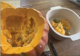  ?? JANET PODOLAK — FOR THE NEWS-HERALD ?? After slicing off the top of the pumpkin, scrape the seeds and stringy flesh from its insides.
