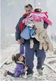  ?? VADIM GHIRDA/THE ASSOCIATED PRESS ?? A child falls while walking with a man on the railway tracks near the border between Greece and Macedonia in the Greek village of Idomeni on Thursday.