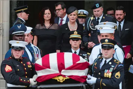  ?? SUSAN WALSH/AP PHOTO ?? Cindy McCain, center, widow of Sen. John McCain, R-Ariz., escorted by her son Jimmy McCain and other family members, follows her husband’s casket as it is carried out of Washington National Cathedral in Washington, D.C., on Saturday following a memorial service. McCain died Aug. 25 from brain cancer at age 81.