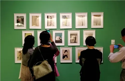  ??  ?? People look at the artworks of Feng Zikai, an influentia­l Chinese painter, at a retrospect­ive exhibition in Hangzhou. — Shi Jia