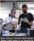  ??  ?? Miss Universe Thailand 2020 Amanda Obdam (right) learns to cut starfruit for food boxes to be distribute­d to the poor, in the kitchen of Chin By Siam Wisdom restaurant in Bangkok.