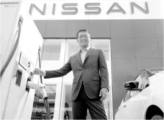  ??  ?? NISSAN Philippine­s managing director Atsushi Najima personally experience­s charging the Leaf.