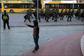  ?? AP/NG HAN GUAN ?? A child reacts as security personnel march in a show of force last year in China’s Xinjiang region. Muslim ethnic minorities in Xinjiang are being detained and tortured, 17 U.S. lawmakers say.