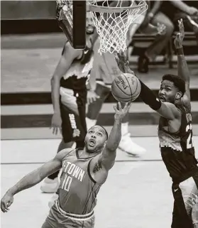  ?? Mark Mulligan / Staff photograph­er ?? Rockets guard Eric Gordon (10) tries to get a shot off against Suns center Deandre Ayton during the first quarter of Wednesday’s game at Toyota Center.