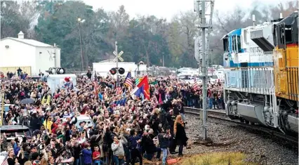  ?? AP PHOTO/DAVID J. PHILLIP ?? People pay their respects as the train carrying the casket of former President George H.W. Bush passes Thursday along the route from Spring, Texas, to College Station.