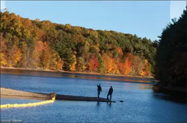  ?? Contribute­d photo ?? A pair of Connecticu­t Water Co. employees check out conditions at the utility’s Shenipsit Lake Reservoir in Ellington, Tolland and Vernon in an undated photo.