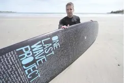  ?? AP PHOTO/STEVEN SENNE ?? Dan Fischer, of Newport, R.I., sits for a photograph with his surfboard recently on Easton’s Beach, in Newport.