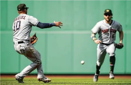  ?? Billie Weiss/Boston Red Sox / Getty Images ?? Neither Astros second baseman Yuli Gurriel nor center fielder Jake Marisnick can corral a ball that falls for a game-tying single.