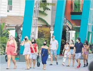  ?? STEPHEN M. DOWELL/ORLANDO SENTINEL ?? Guests stroll at Universal CityWalk on May 14. Universal began limited operation at in CityWalk last week.