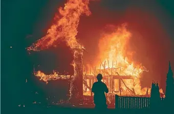  ?? AP ?? In this November 8, 2018 file photo, a home burns as a Camp Fire rages through Paradise, California.