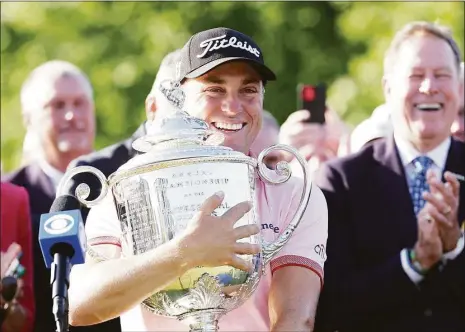  ?? Richard Heathcote / Getty Images ?? Justin Thomas celebrates with the Wanamaker Trophy after putting in to win on the third playoff hole of the PGA Championsh­ip on Sunday in Tulsa, Okla.