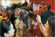  ?? TAWANA ROBERTS– THE NEWS-HERALD ?? New U.S. citizens rejoice after taking the oath of allegiance at the naturaliza­tion ceremony in Mentor on July 7.