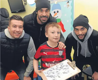  ?? Picture: Kim Cessford. ?? Dundee fan Kai Nicoll, 7, with, from left, Dens players Cameron Kerr, Sofien Moussa and Faissal El Bakhtaoui at Tayside Children’s Hospital in Ninewells.