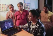  ?? ERANGA JAYAWARDEN­A, THE ASSOCIATED PRESS ?? Relatives of Premnath Ruwan Sampath, one of the captured Sri Lankan crew members, show one of his wedding photograph­s.