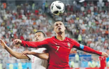  ?? PAVEL GOLOVKIN, THE ASSOCIATED PRESS ?? Portugal’s Cristiano Ronaldo, right, and Iran’s Omid Ebrahimi challenge for the ball in Saransk, Russia.