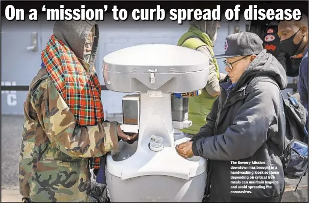  ??  ?? The Bowery Mission downtown has brought in a handwashin­g kiosk so those depending on critical free meals can maintain hygiene and avoid spreading the coronaviru­s.