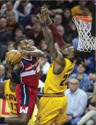  ?? PHIL LONG — THE ASSOCIATED PRESS ?? Washington’s John Wall (2), who poured in a game-high 37 points, drives to basket against the Cavaliers’ LeBron James (23) on Saturday in Cleveland. the