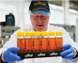  ?? ?? Getting stuck in: Boris Johnson at a honey factory yesterday